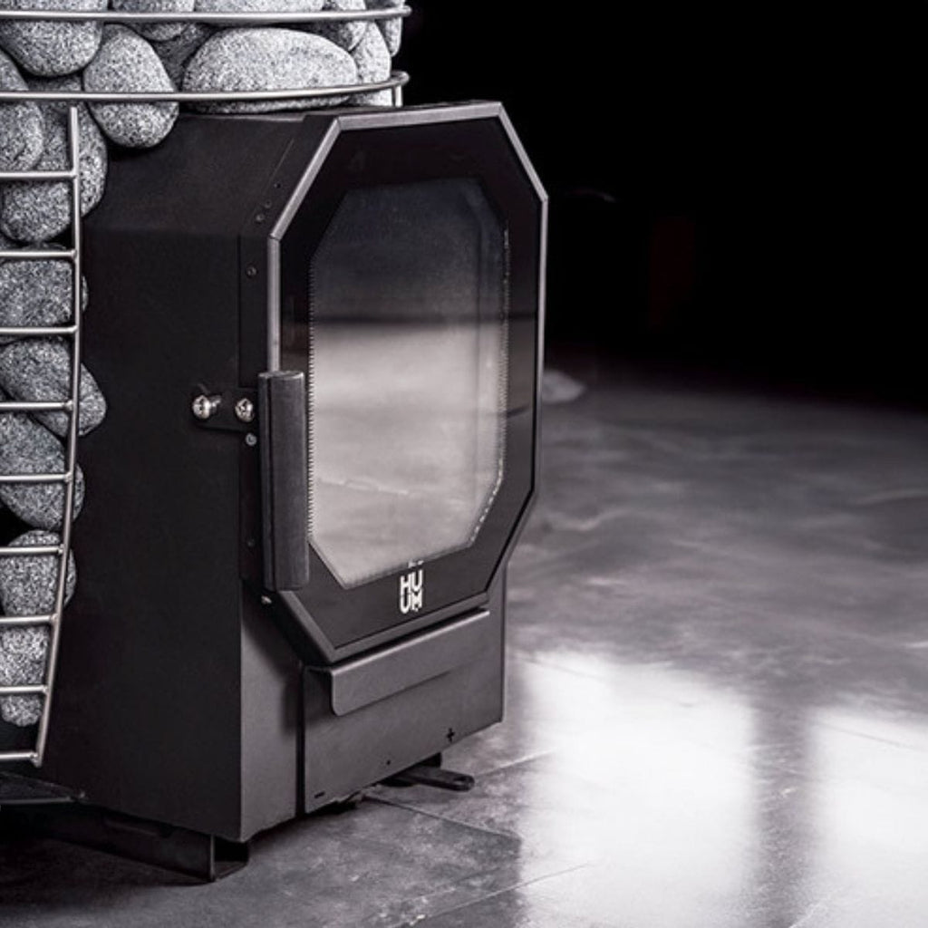 Black fireplace insert with glass door in a stone fireplace setting