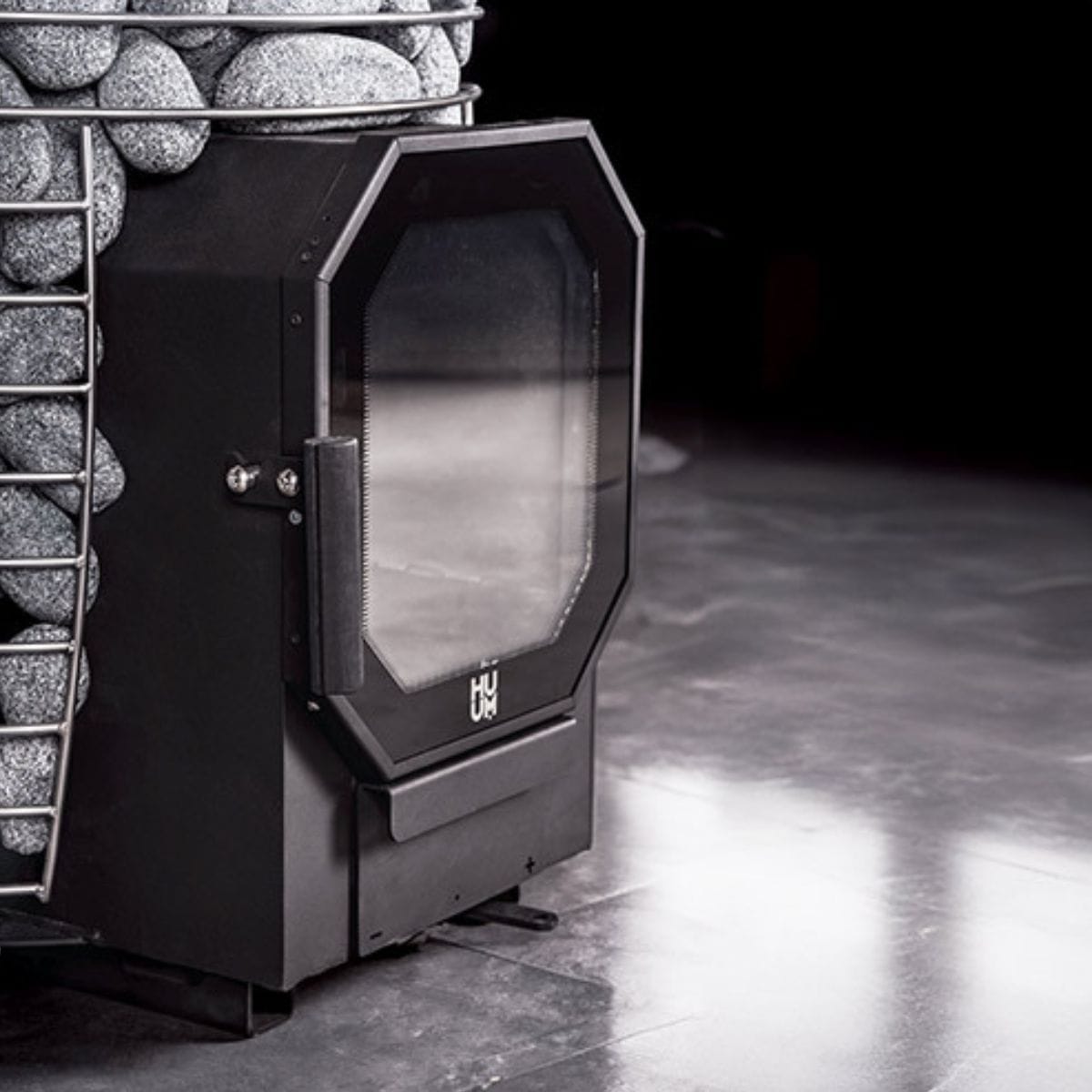 Black fireplace insert with glass door in a stone fireplace setting