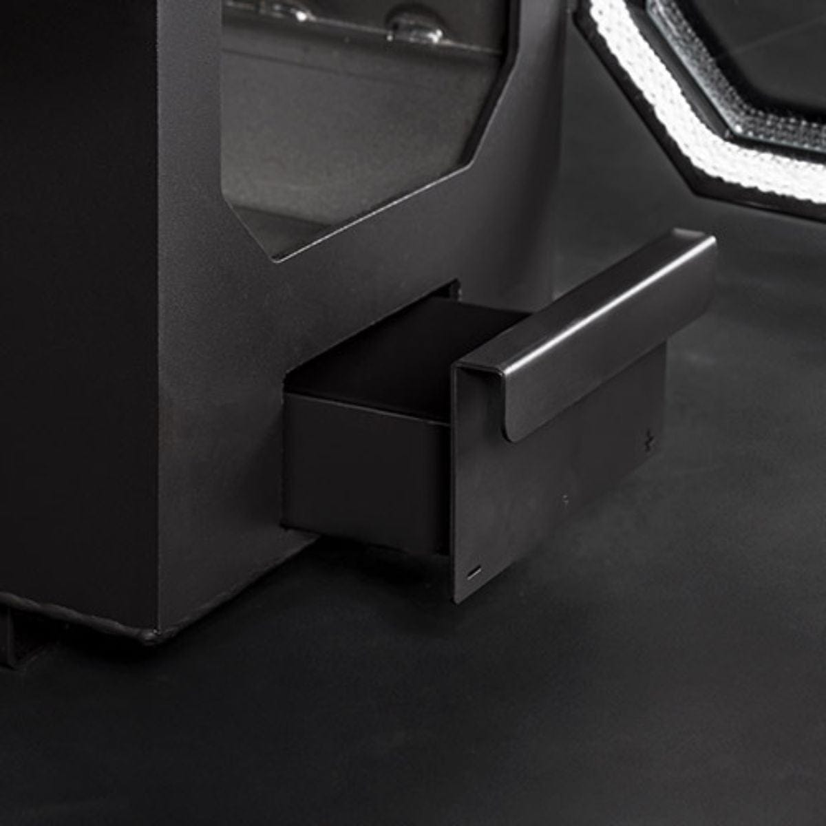 Close-up of a black drawer with a metallic handle on a dark background