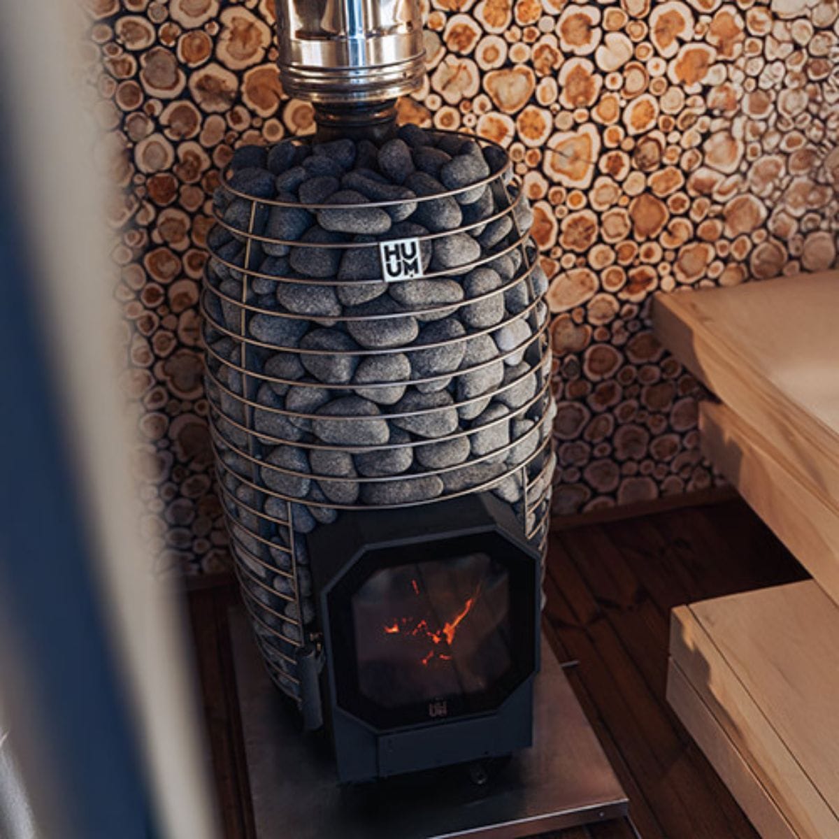 Stacked stone stove with a decorative wood wall in the background