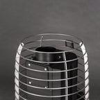 Black metal cylindrical object with wire cage on a dark background