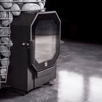 Black fireplace insert with glass door in a dimly lit room.