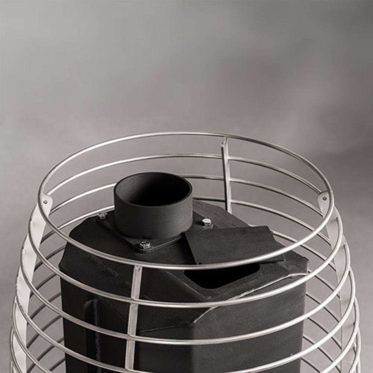 Black cylindrical object with a metal wire cage on a gray background