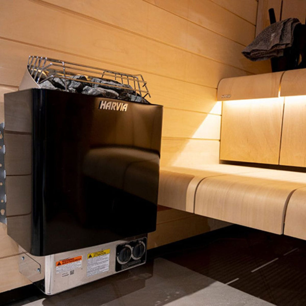 Black Harvia sauna heater in a wooden sauna room.