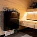 Black Harvia sauna heater in a wooden sauna room.