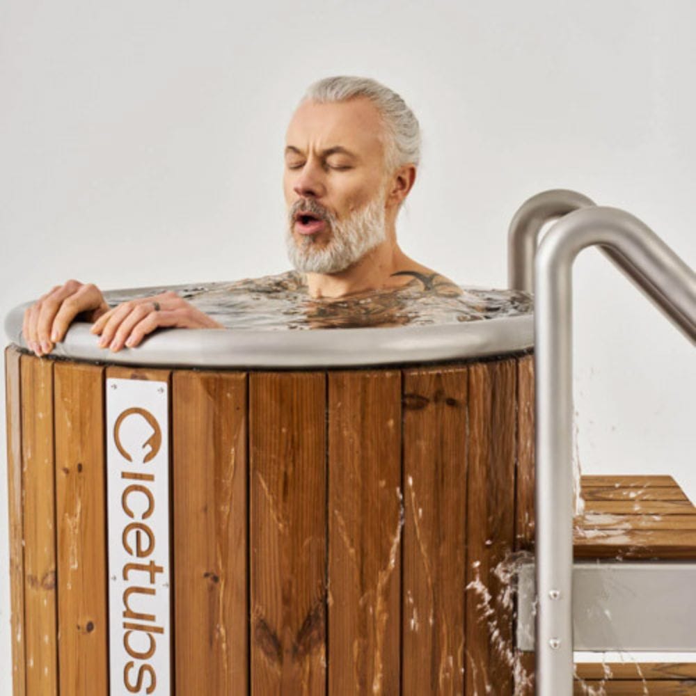 Man with closed eyes leaning over a wooden hot tub with 'Cicetubs' branding.