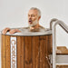 Man with closed eyes leaning over a wooden hot tub with 'Cicetubs' branding.