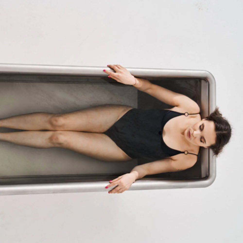 Woman lying on a metallic surface with a neutral background