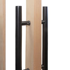 Close-up of a wooden door with black metal handles on a white background