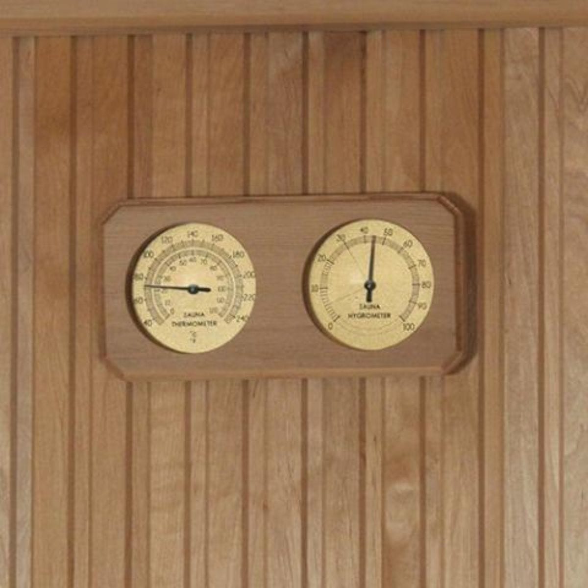 Wooden panel with a dual gauge thermometer and hygrometer on a wooden background