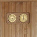 Wooden panel with a dual gauge thermometer and hygrometer on a wooden background