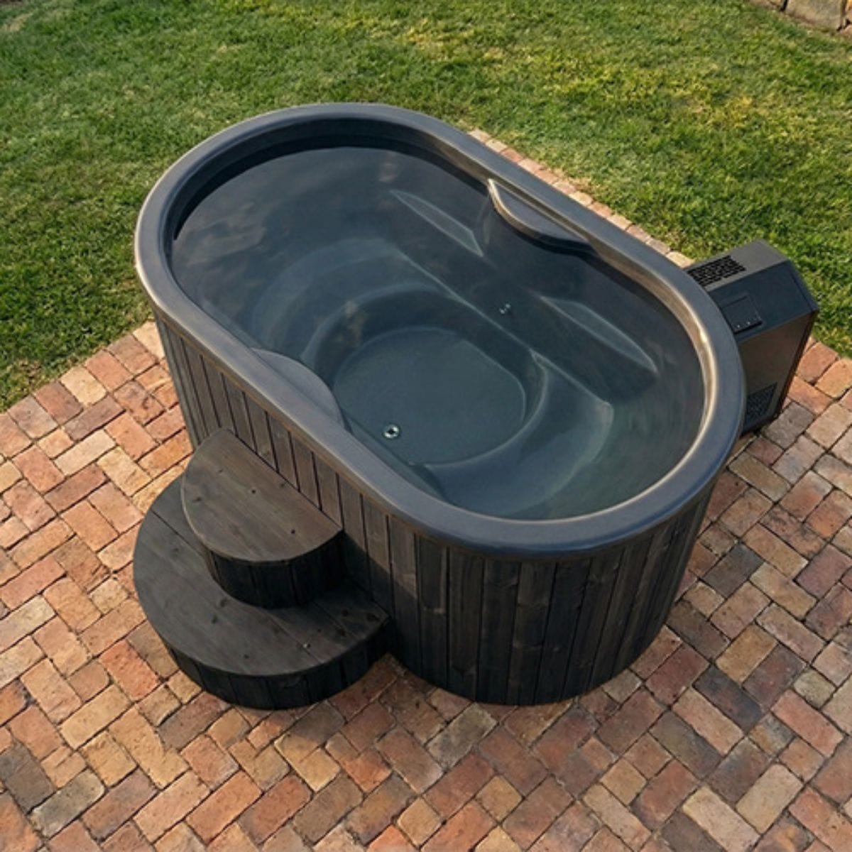 Portable hot tub on a brick patio with grass in the background