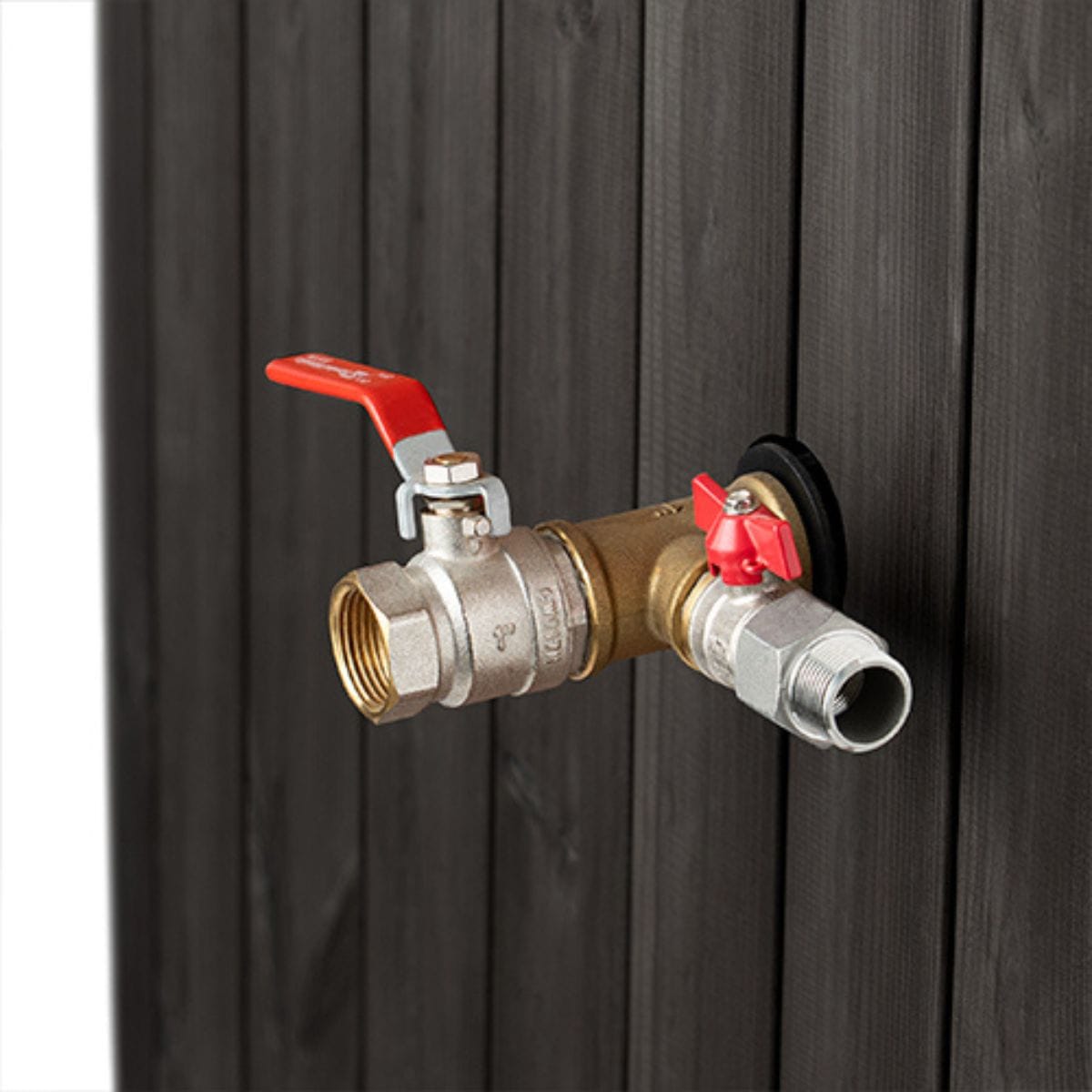 Brass valve with red handles attached to a black metal surface