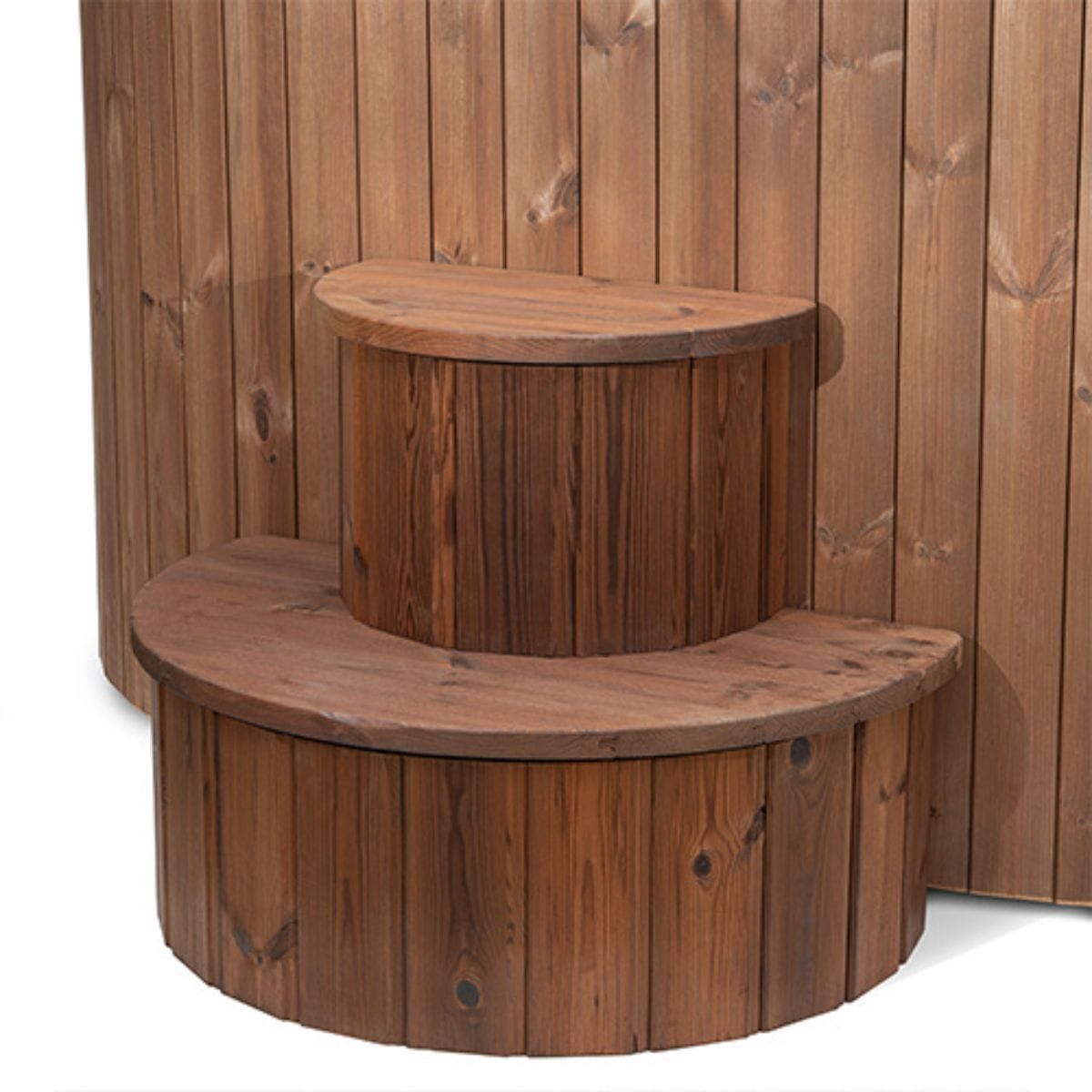 Wooden steps with a round design against a wooden wall.